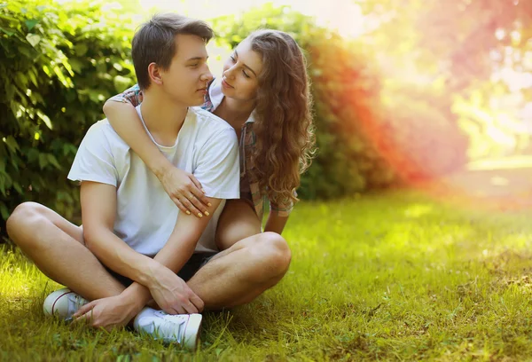 Adorável jovem casal adolescente apaixonado se divertindo no gramado no parque, em — Fotografia de Stock