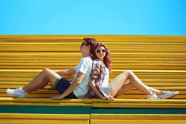 Solig sommar porträtt snygg ung cool par tonåringar vila på th — Stockfoto