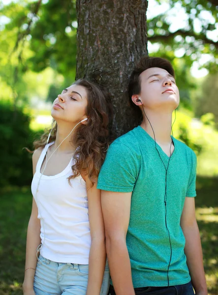 Adolescentes, cara e menina em fones de ouvido gostando de ouvir música em — Fotografia de Stock