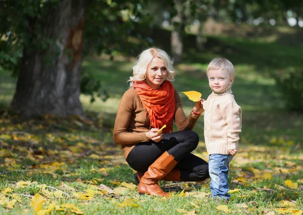 Madre e hijo divirtiéndose en el parque de otoño — Foto de Stock