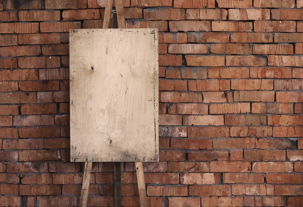 Cavalete grunge em branco em uma parede de tijolo, fundo de arte — Fotografia de Stock