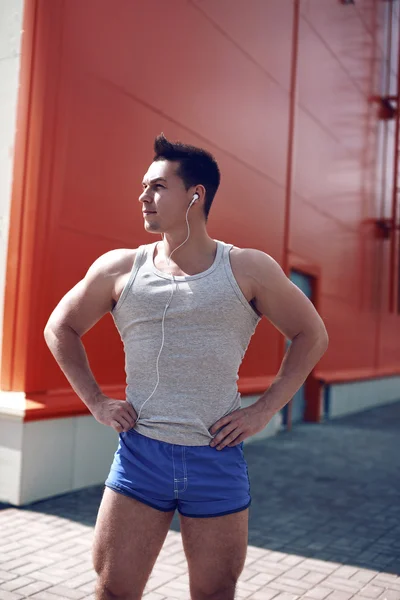 Hombre deportivo guapo posando en la ciudad, entrenamiento, fitness, deporte — Foto de Stock