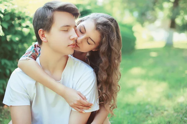 Mooie jonge paar tieners in de liefde, kus buitenshuis — Stockfoto