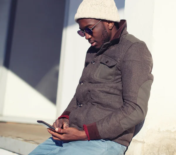 Portrait de style de vie d'un jeune homme africain élégant utilisant un smartphone — Photo