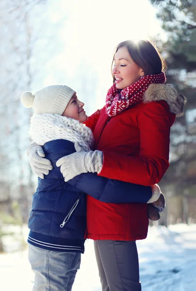 Retrato de la vida de la familia feliz, el hijo abraza a su madre en el soleado invierno —  Fotos de Stock