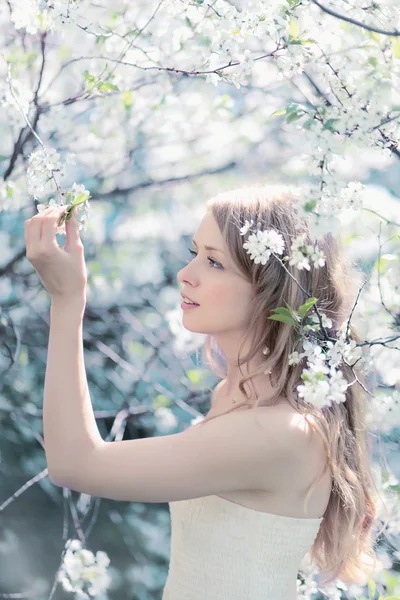 Portrait printanier ensoleillé d'une belle femme touchant des pétales dans un — Photo