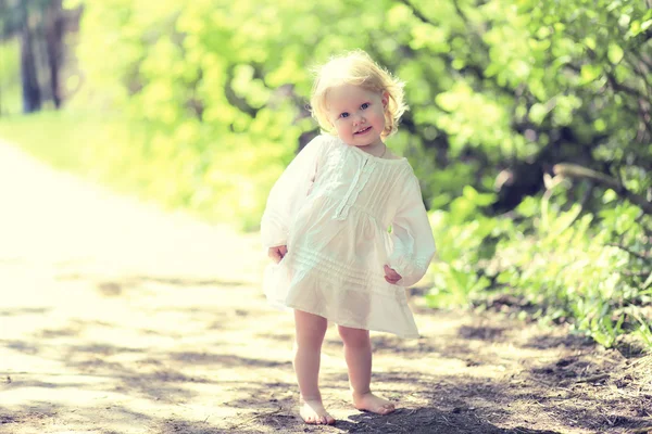 Bambino carino soleggiato a piedi nudi nella giornata estiva, colori caldi e tonici — Foto Stock