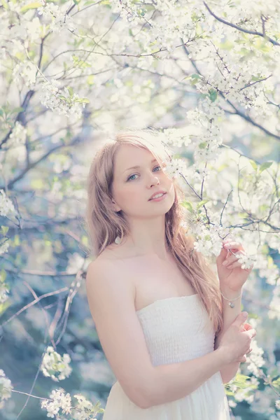 Sunny portrét krásné mladé ženy v kvetoucích na jaře — Stock fotografie
