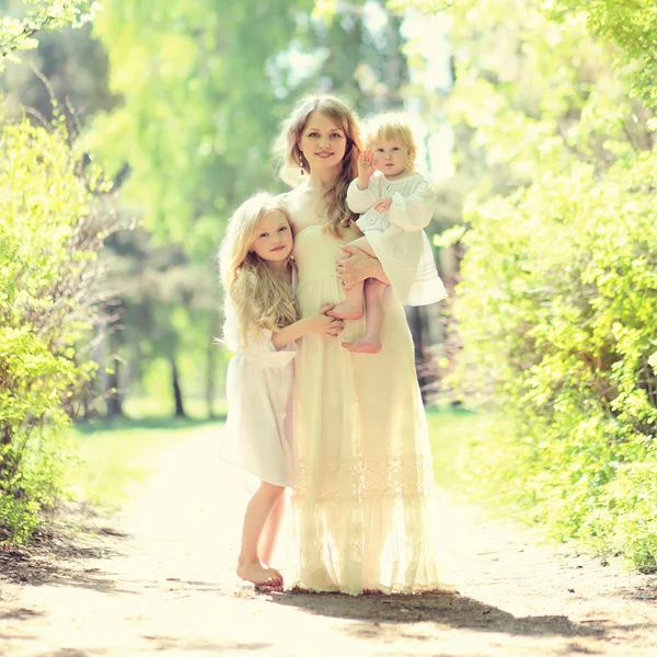 Sunny portrait of happy family on the nature, young mother huggi — Stock Photo, Image