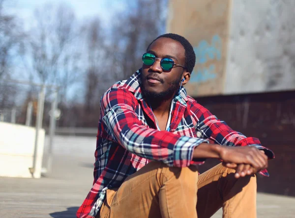 Utomhus mode porträtt av snygg ung afrikansk man lyssnar på — Stockfoto