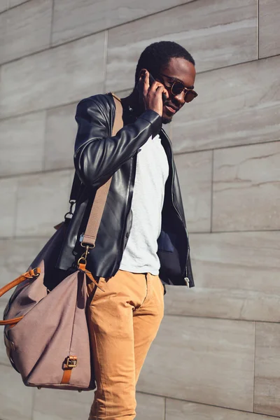 Portrait extérieur de jeune homme africain marchant et parlant sur le — Photo