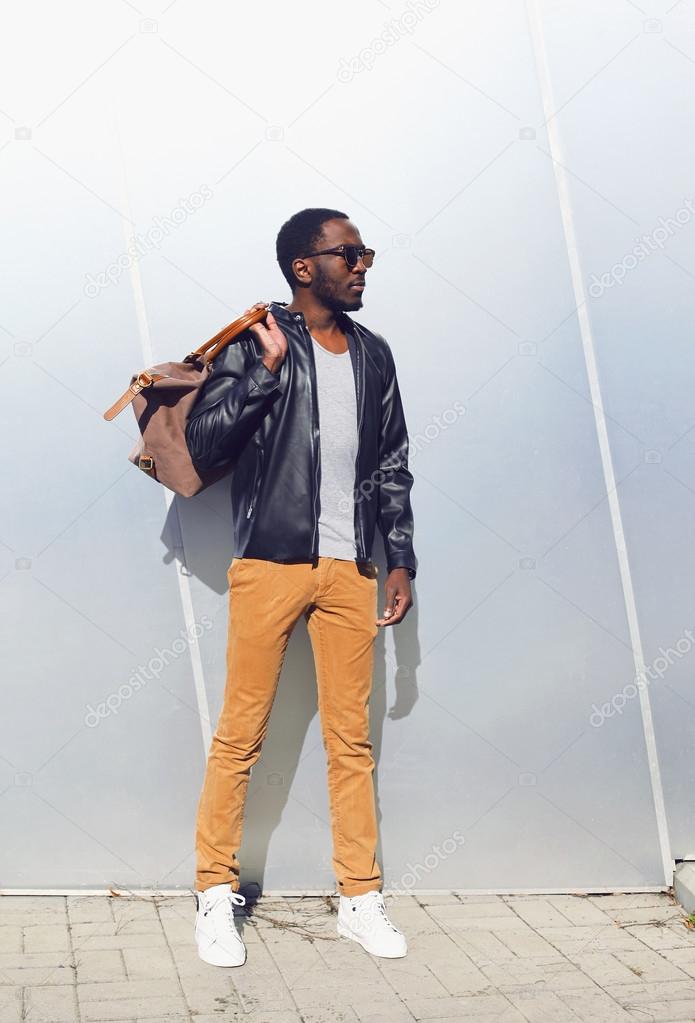 Outdoor fashion portrait of handsome african man in black leathe