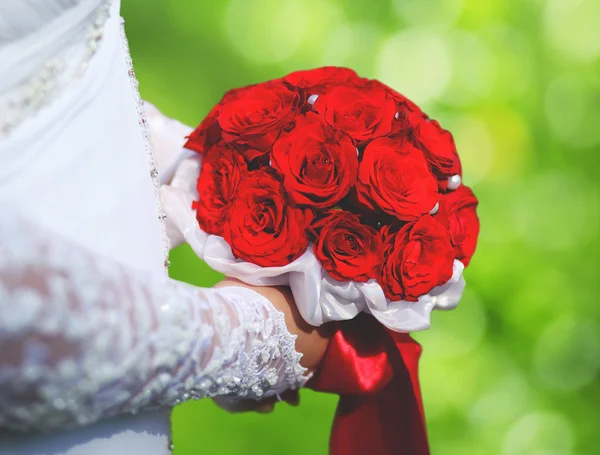 Esküvői elegáns csokor vörös rózsa virágok kezek menyasszony a su — Stock Fotó