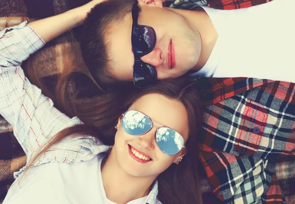 Nahaufnahme Porträt eines glücklichen jungen Paares mit Sonnenbrille auf dem Rücken liegend — Stockfoto