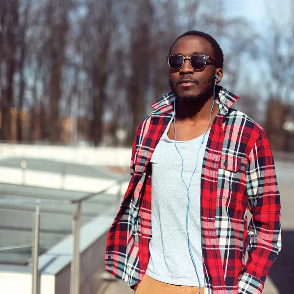 Retrato de moda de jovem homem africano elegante ouve música i — Fotografia de Stock