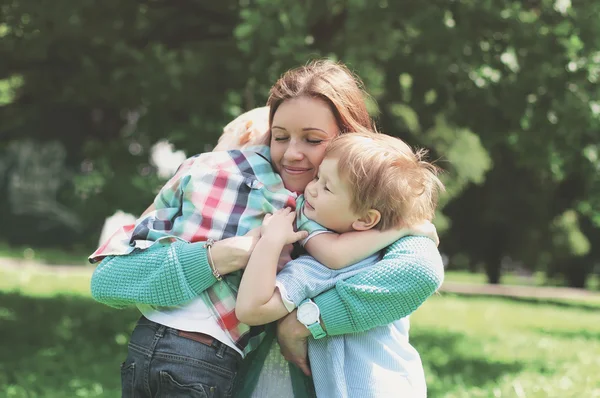 ¡Felicidad familiar! Feliz madre abrazando tiernamente a sus dos hijos i —  Fotos de Stock