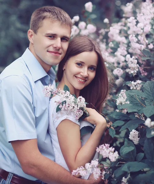 Portrait de beau jeune couple dans la garde printanière fleurie — Photo