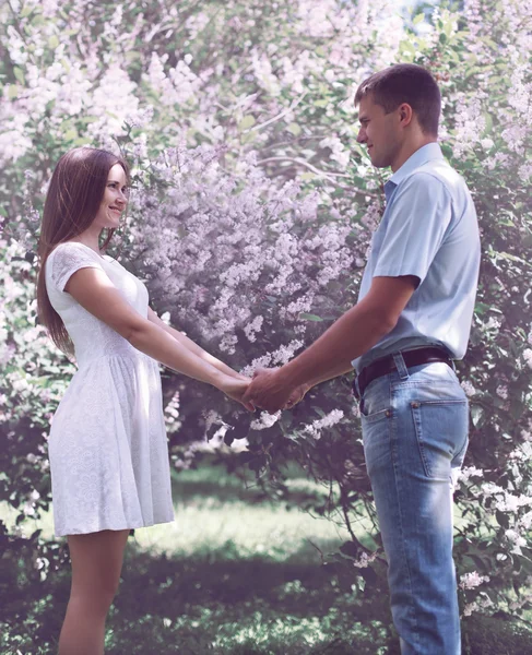 Söt unga par i kärlek mot den blommande vår trädgården — Stockfoto