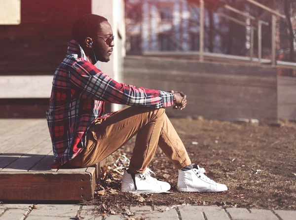 Lifestyle fashion portrait of stylish young african man listens — Stock Photo, Image