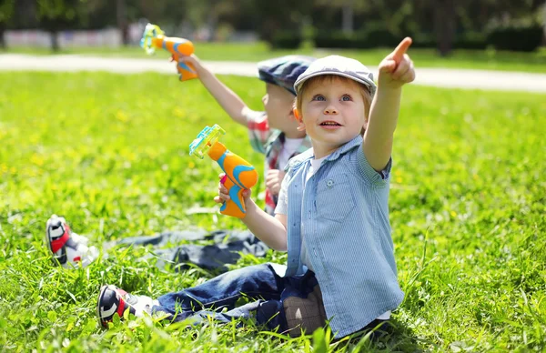 Porträt von zwei Jungen, die auf dem Gras sitzen und spielen — Stockfoto