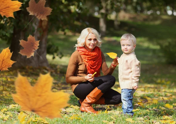 幸せママと飛んで、暖かい秋の日に一緒に遊ぶ子供 — ストック写真