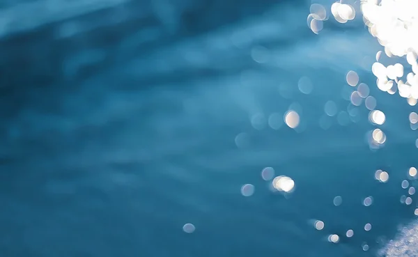 Błękitne wody rozmazane tło, fale morza z bokeh — Zdjęcie stockowe
