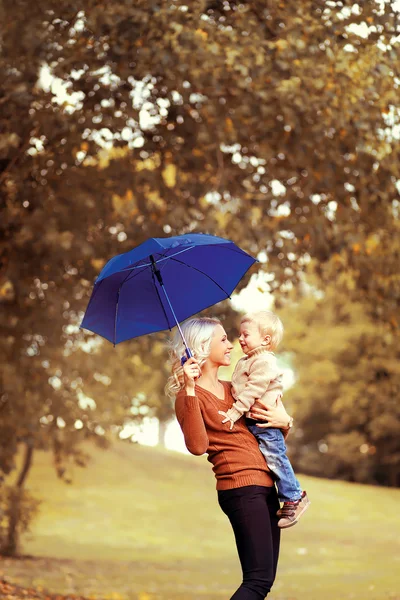 Family in autumn! Happy mother and child with umbrella having fu — Stock Photo, Image