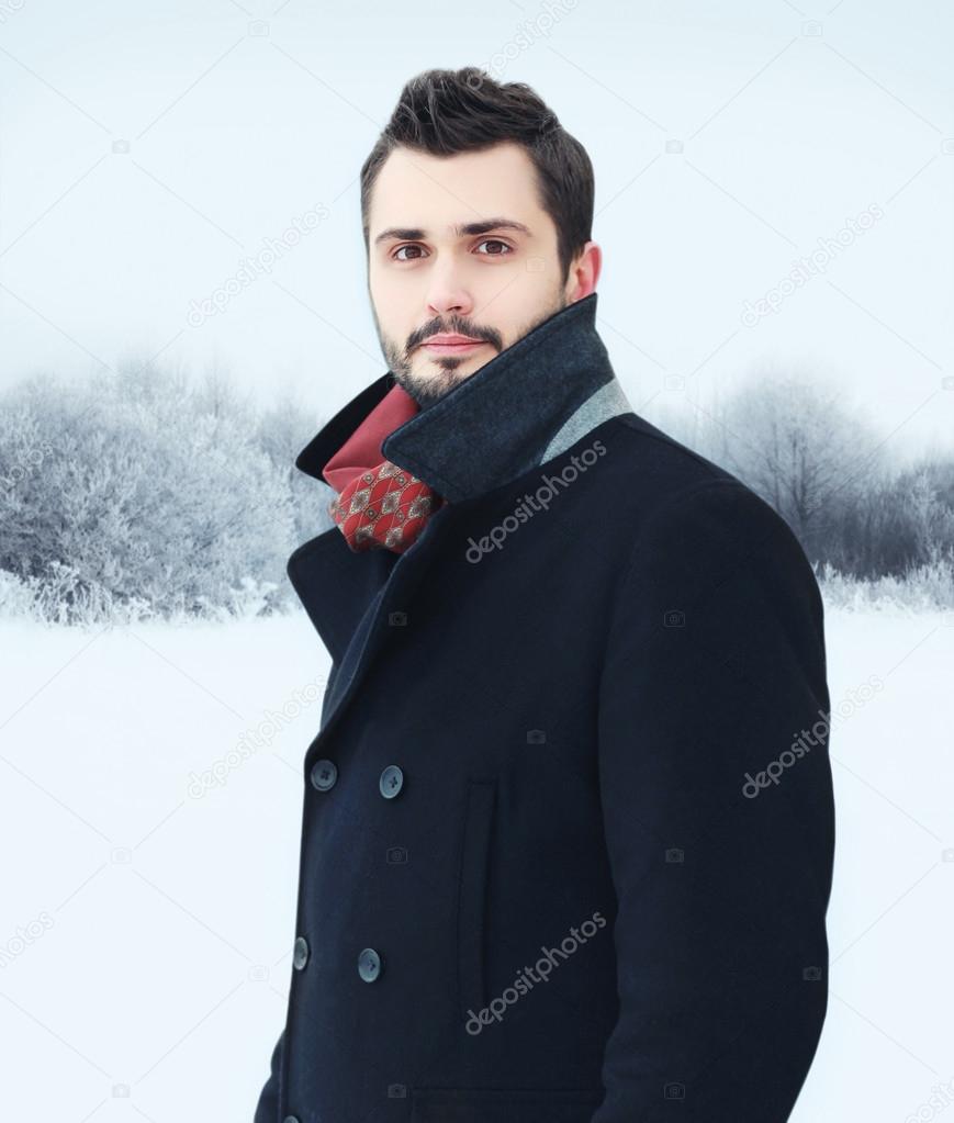 Fashion portrait handsome bearded man wearing black coat in wint