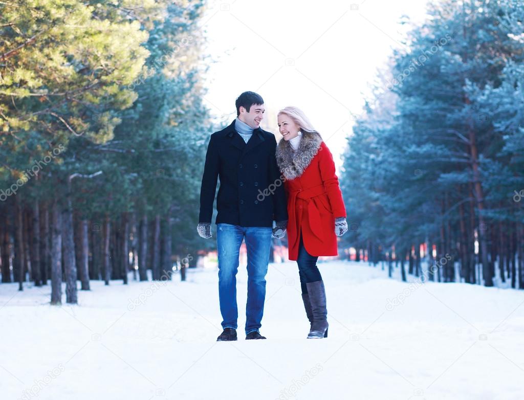 Happy beautiful couple walking together and having fun in winter