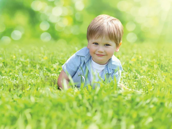 Portrait cute smiling child lying on grass in sunny summer day o — Stock Photo, Image