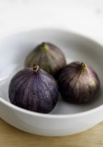 Färska mogna fikon i vit keramik skål — Stockfoto