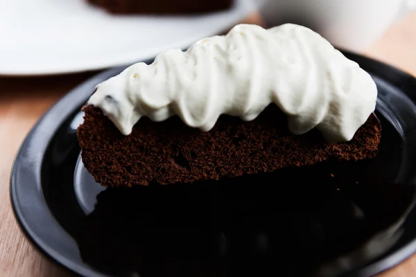 Closeup of piece of chocolate cake with a cream — Stock Photo, Image