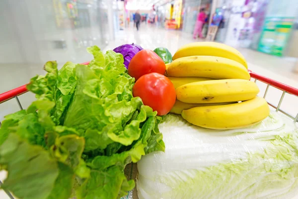 Winkelwagen met groenten en fruit — Stockfoto