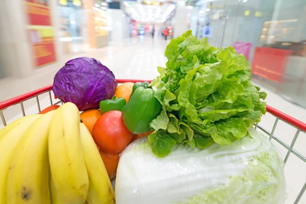 Winkelwagen met groenten en fruit — Stockfoto