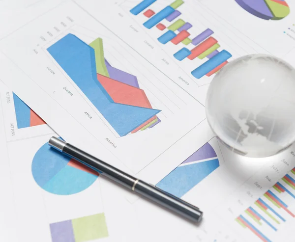 Globe och diagram på skrivbord — Stockfoto