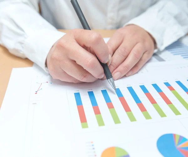 Woman hand with pen and business report — Stock Photo, Image