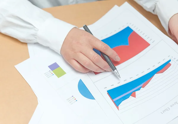 Frauenhand mit Stift und Geschäftsbericht — Stockfoto