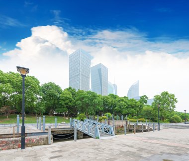 City park with modern buildings clipart
