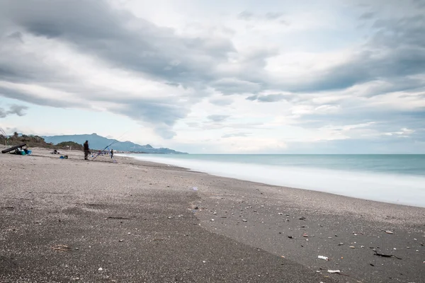 Strand met visser — Stockfoto