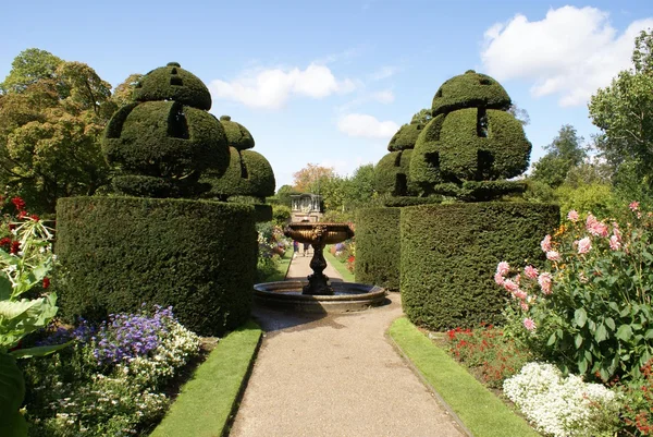 Sculptured fountain and topiary trees. garden. pathway. park. outdoor view or scene — Stock Photo, Image