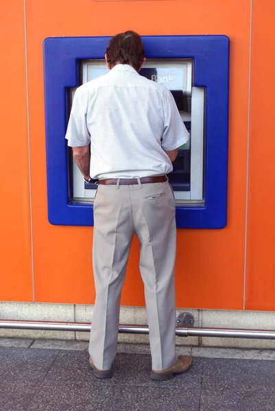 Чоловік використовує банкомат. отвір у стіні. грошова машина — стокове фото