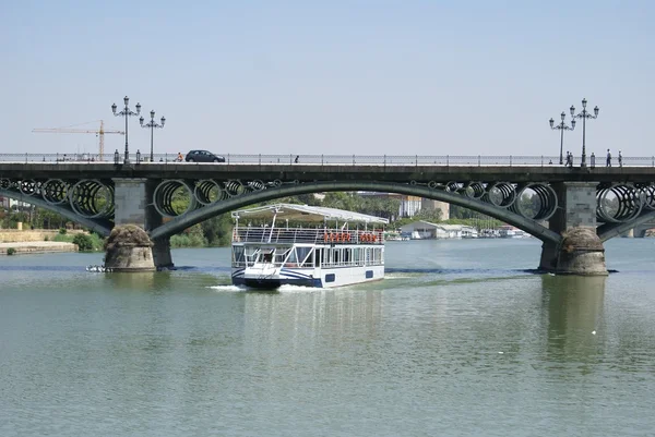 Cruiser, Triana híd, a Guadalquivir-folyó, a Sevilla, Andalúzia, Spanyolország — Stock Fotó