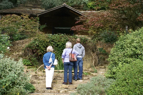 Visitors looking at an ancient summerhouse in a garden — Stock Photo, Image