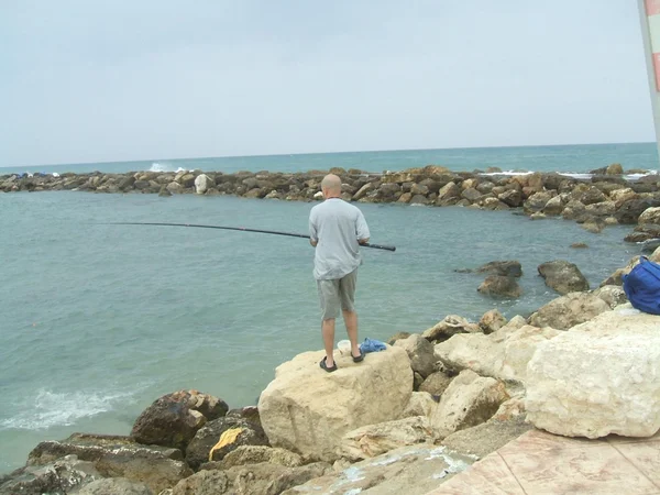 Homem pesca em um mar — Fotografia de Stock