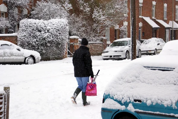 Vista esterna sulla neve urbana. Donna che cammina per strada, Inghilterra — Foto Stock