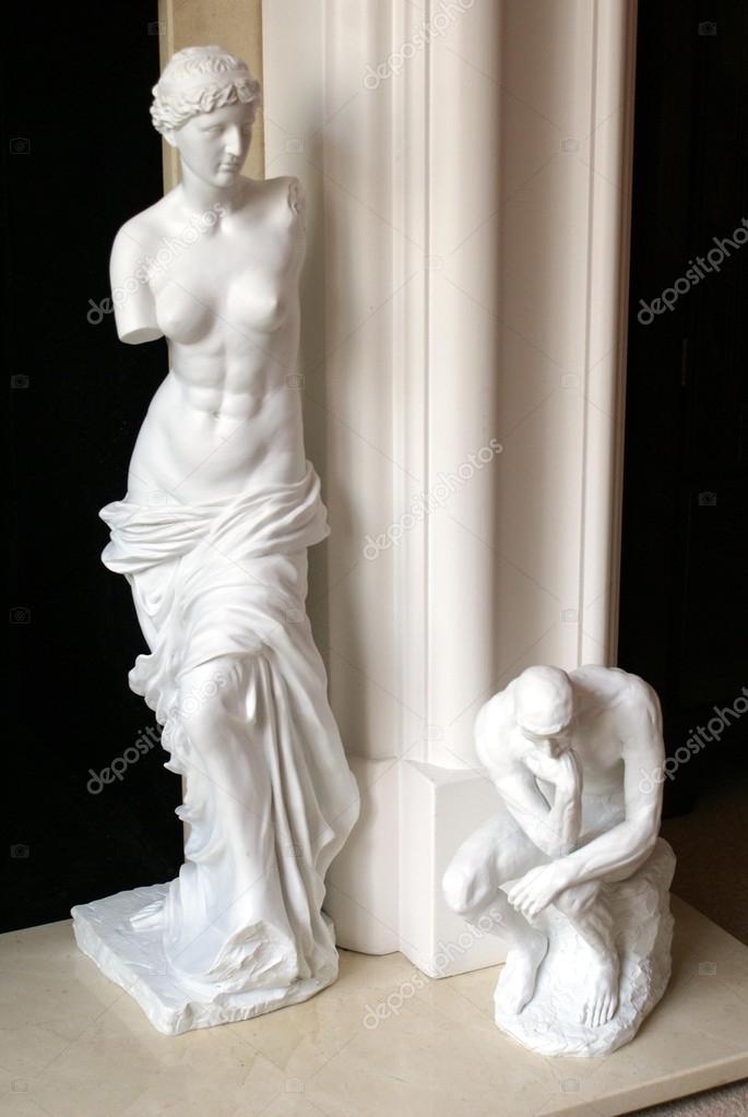 Statues of a man sitting thinking. statue of a Greek armless naked woman