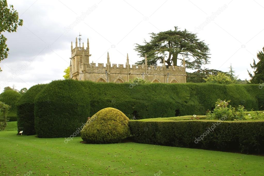 Yew hedge surrounding church. garden, St Mary Church, Sudeley castle, England