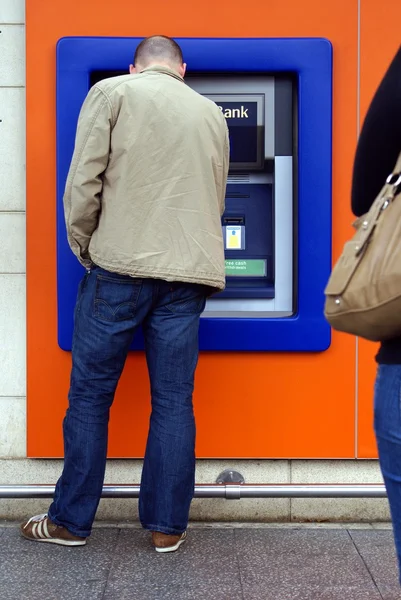 Un hombre usando un cajero automático. Cajero automático. Punto de pago. una máquina bancaria. agujero en la pared — Foto de Stock