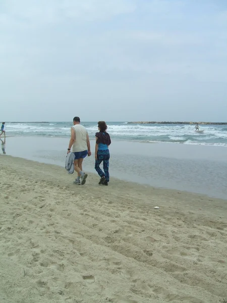 Coppia passeggiando lungo la spiaggia — Foto Stock