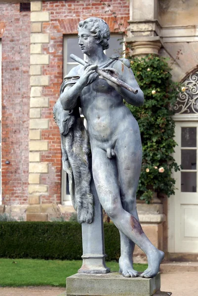 Statue of a musician playing flute, Powis Castle Garden, Wales, England